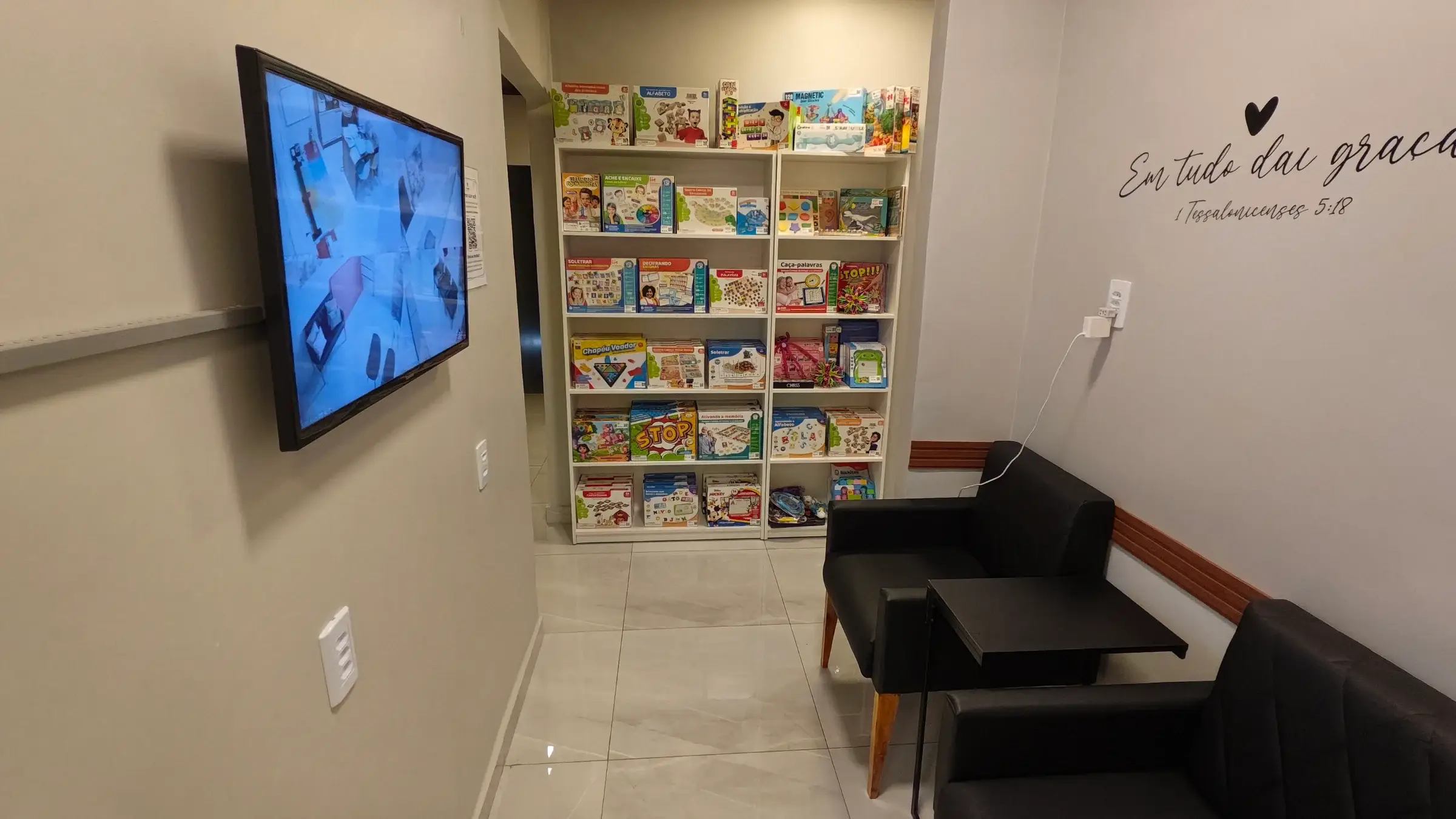 Estante com jogos educativos ao lado de uma poltrona na sala de monitoramento
