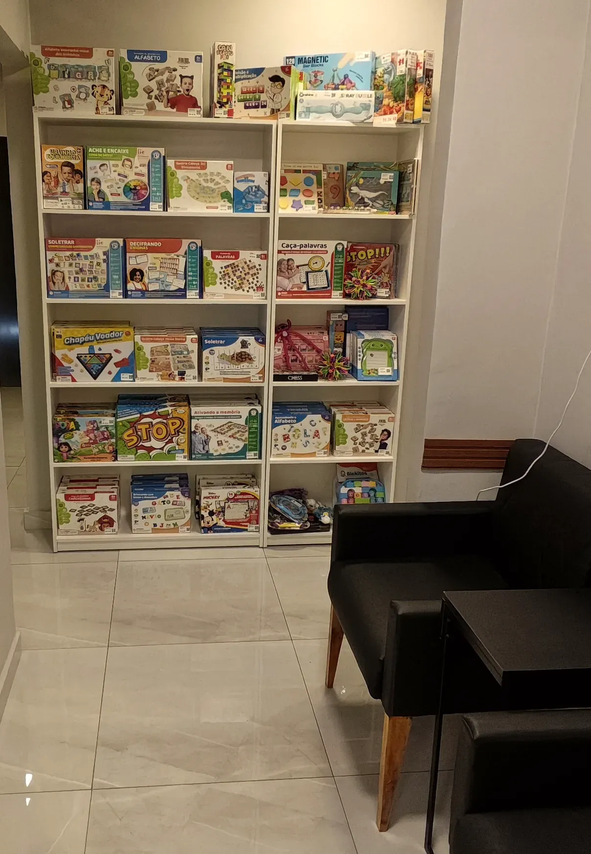Estante com jogos e materiais na clínica Progride