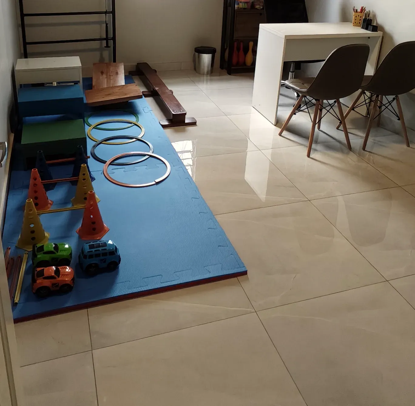 Sala de terapia da Progride com tatame azul, cones, argolas e materiais para atividades motoras