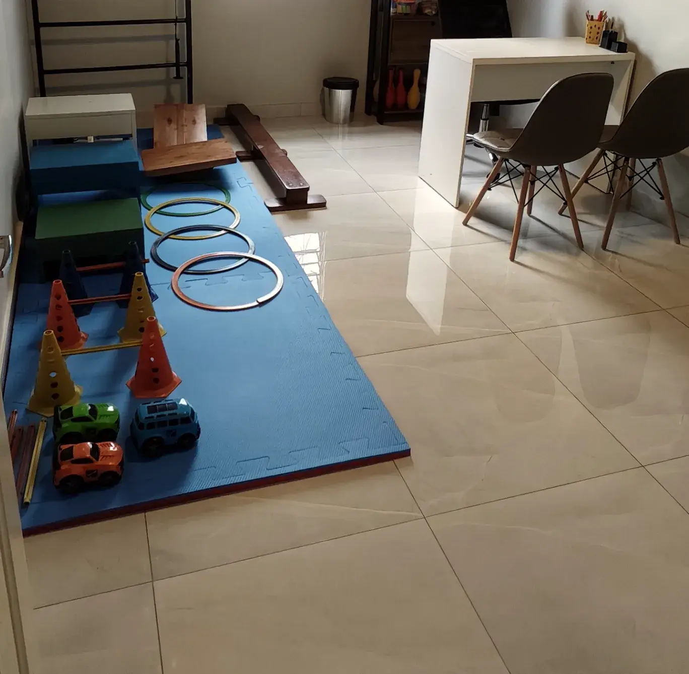 Sala de terapia da Progride com tatame azul, cones, argolas e materiais de atividades motoras
