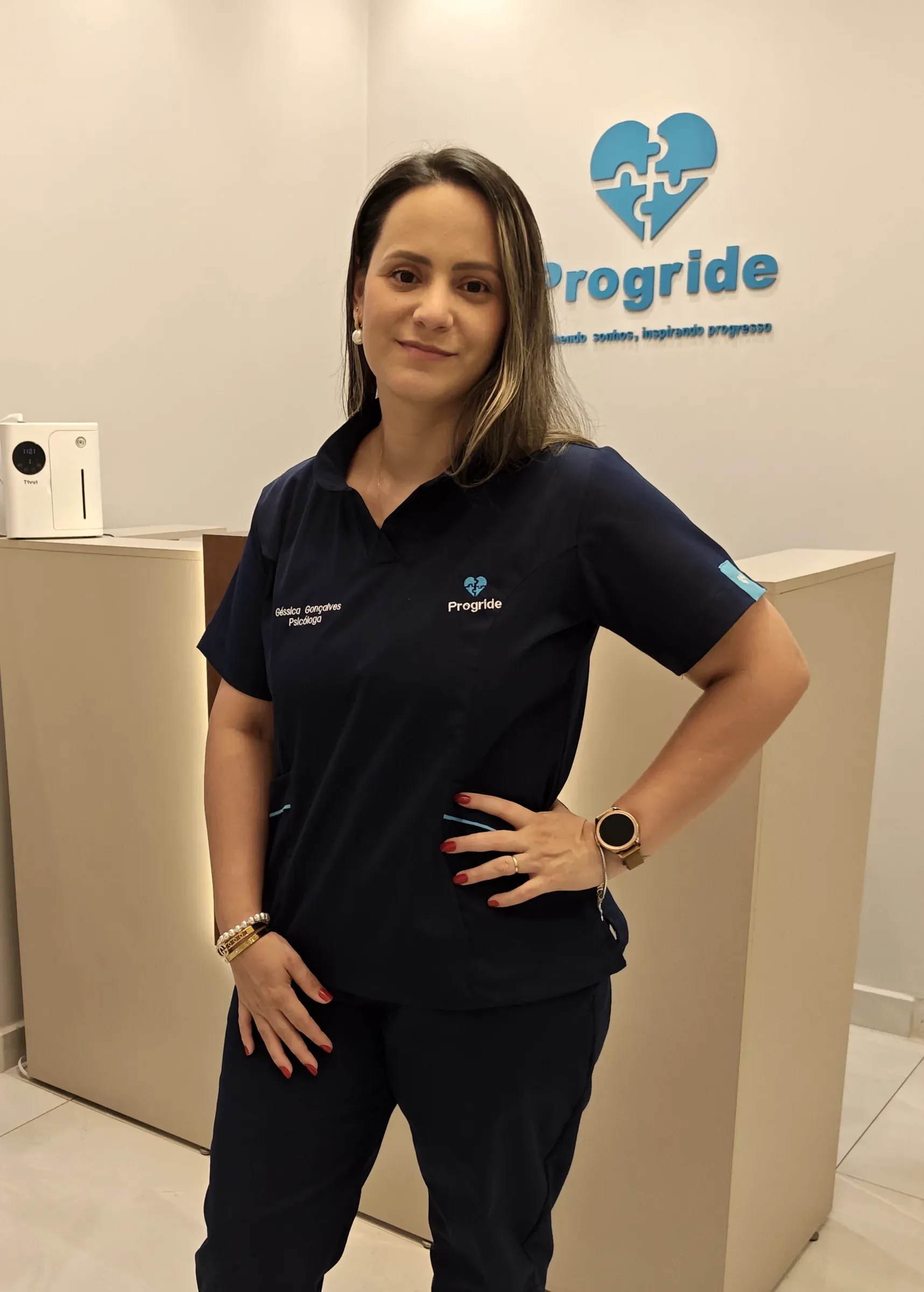 Géssica Gonçalves na recepção da Progride, com o uniforme da clínica